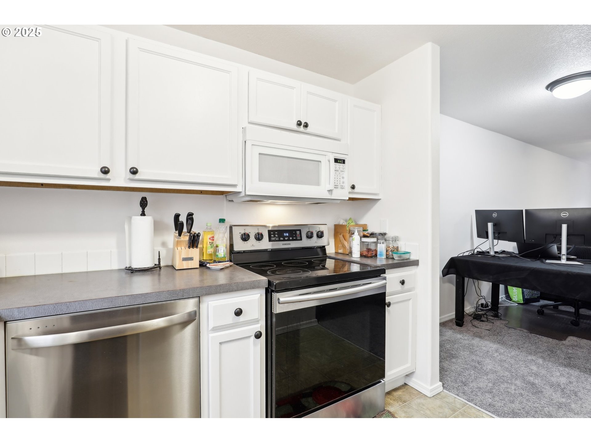 19153 Southeast Yamhill Street, Unit 21 Portland, OR 97233 - Photo 8 of 22 a kitchen with stainless steel appliances granite countertop a stove a sink and white cabinets