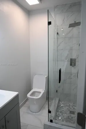 a bathroom with a toilet and a shower