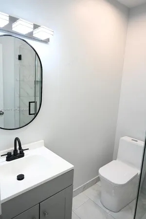 a bathroom with a sink mirror and toilet