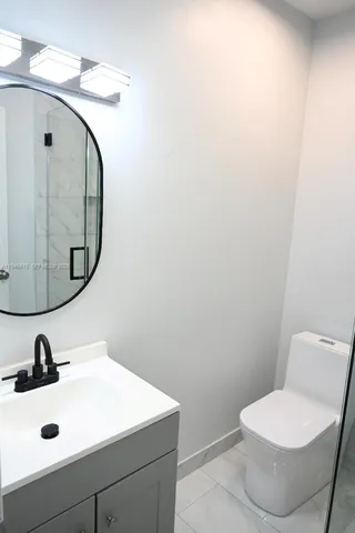 a bathroom with a sink mirror and toilet