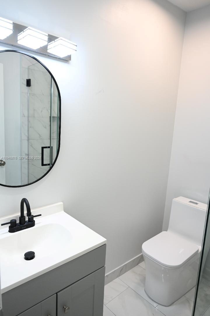 7545 Northwest 3rd Avenue, Unit 4 Miami, FL 33150 - Photo 4 of 6 a bathroom with a sink mirror and toilet