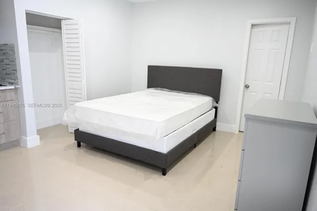 a bed sitting in a bedroom next to a window