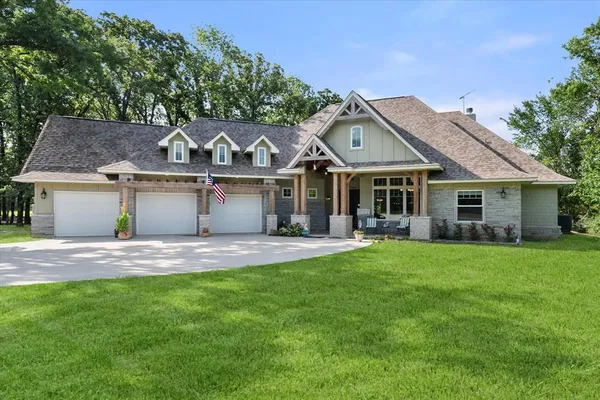 a front view of a house with a garden and yard