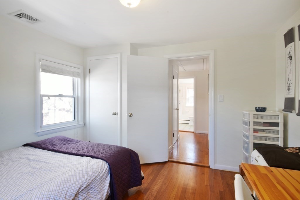 130 Florence Road Waltham, MA 02453 - Photo 21 of 26 a bedroom with a bed and wooden floor