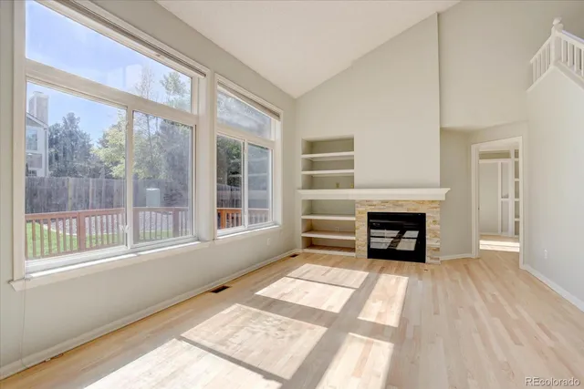 a view of an empty room with a fireplace and a window