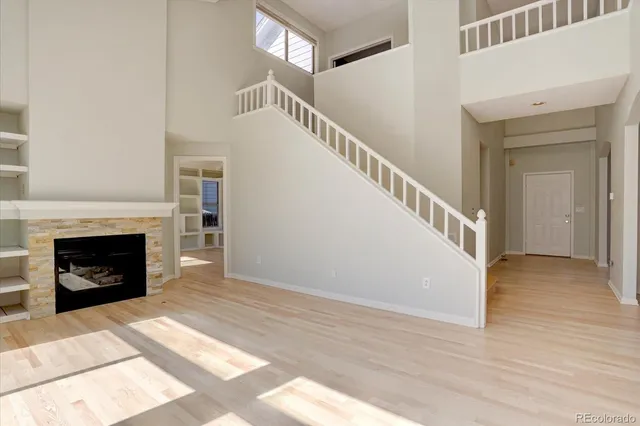 a view of a livingroom with wooden floor and a fireplace