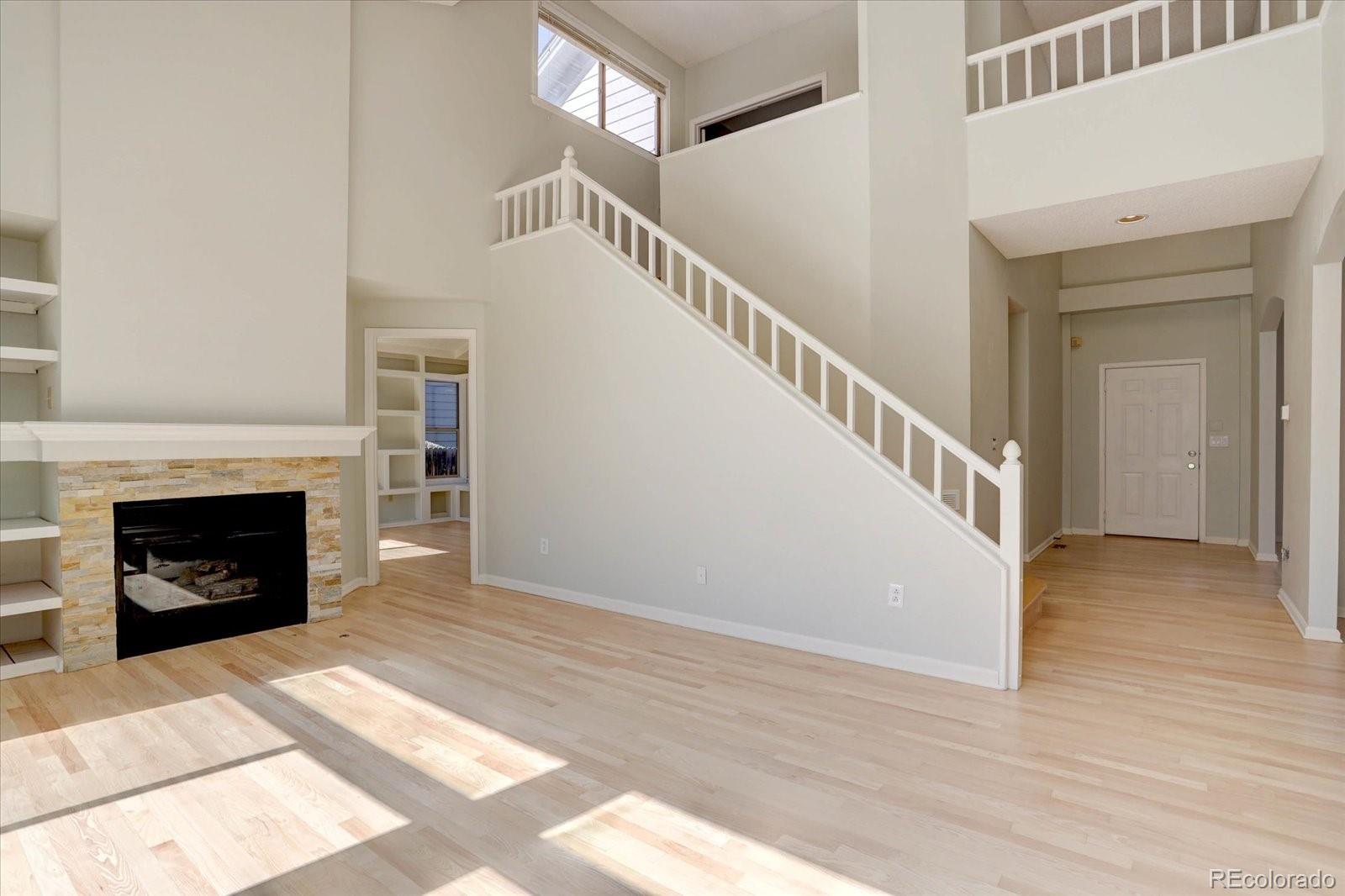10312 Stoneflower Drive Parker, CO 80134 - Photo 14 of 43 a view of a livingroom with wooden floor and a fireplace