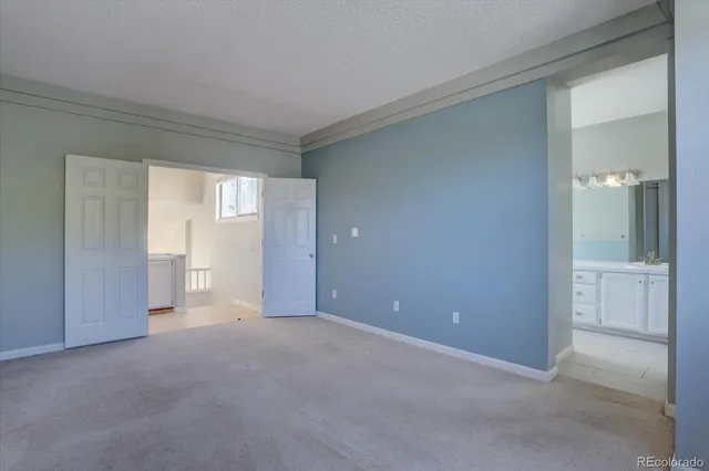 a view of an empty room with closet and a window