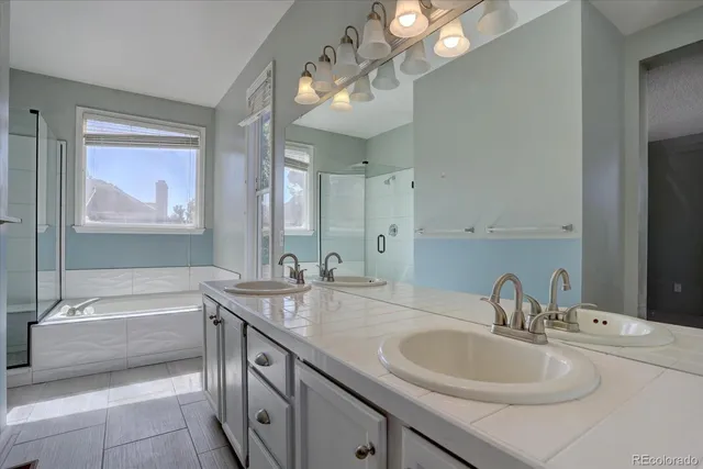 a bathroom with a sink double vanity granite tub and a mirror