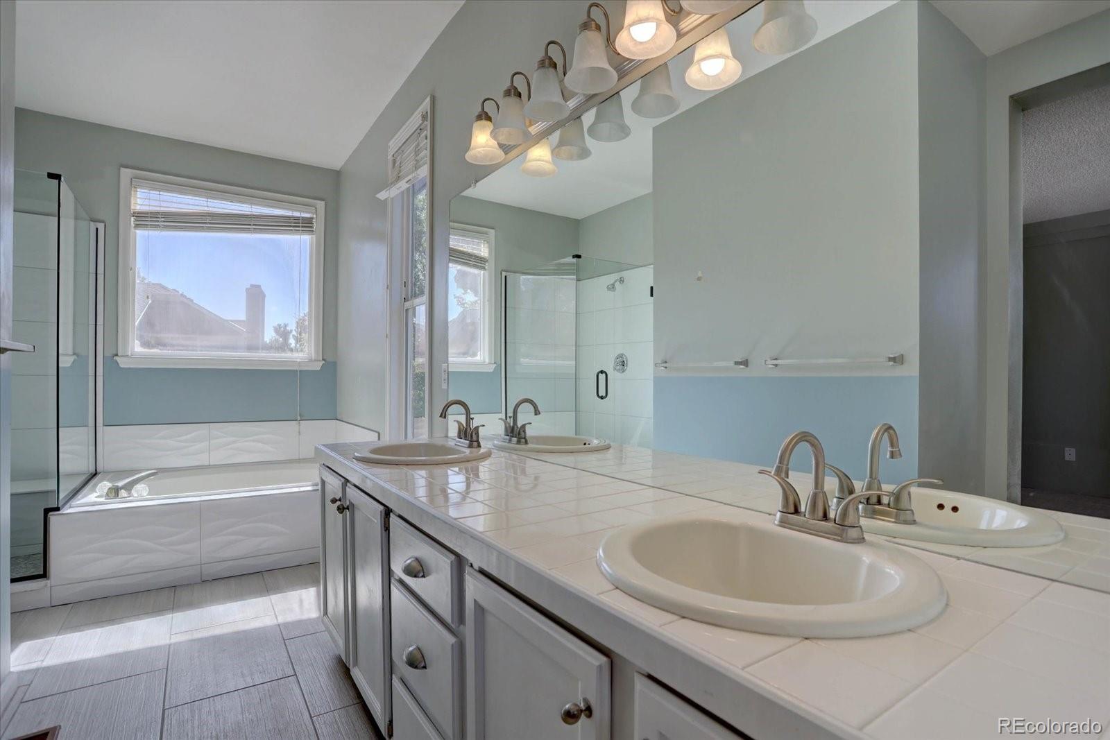 10312 Stoneflower Drive Parker, CO 80134 - Photo 21 of 43 a bathroom with a sink double vanity granite tub and a mirror