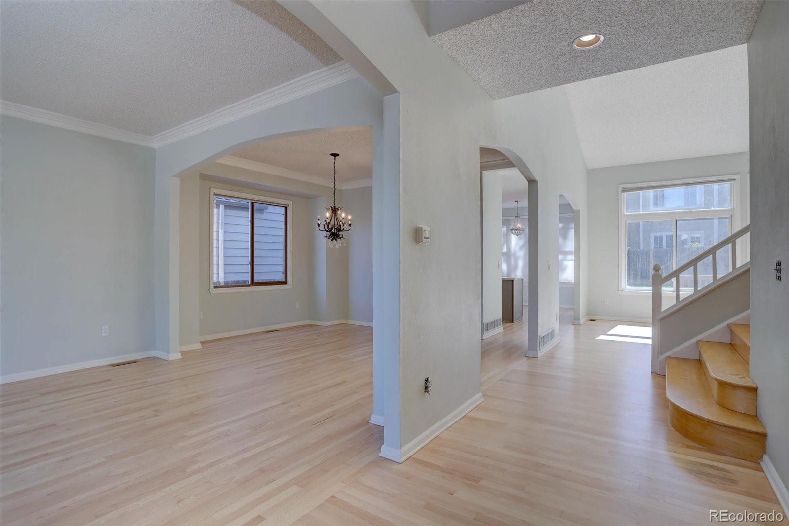 10312 Stoneflower Drive Parker, CO 80134 - Photo 3 of 43 a view of an entryway with wooden floor and a livingroom