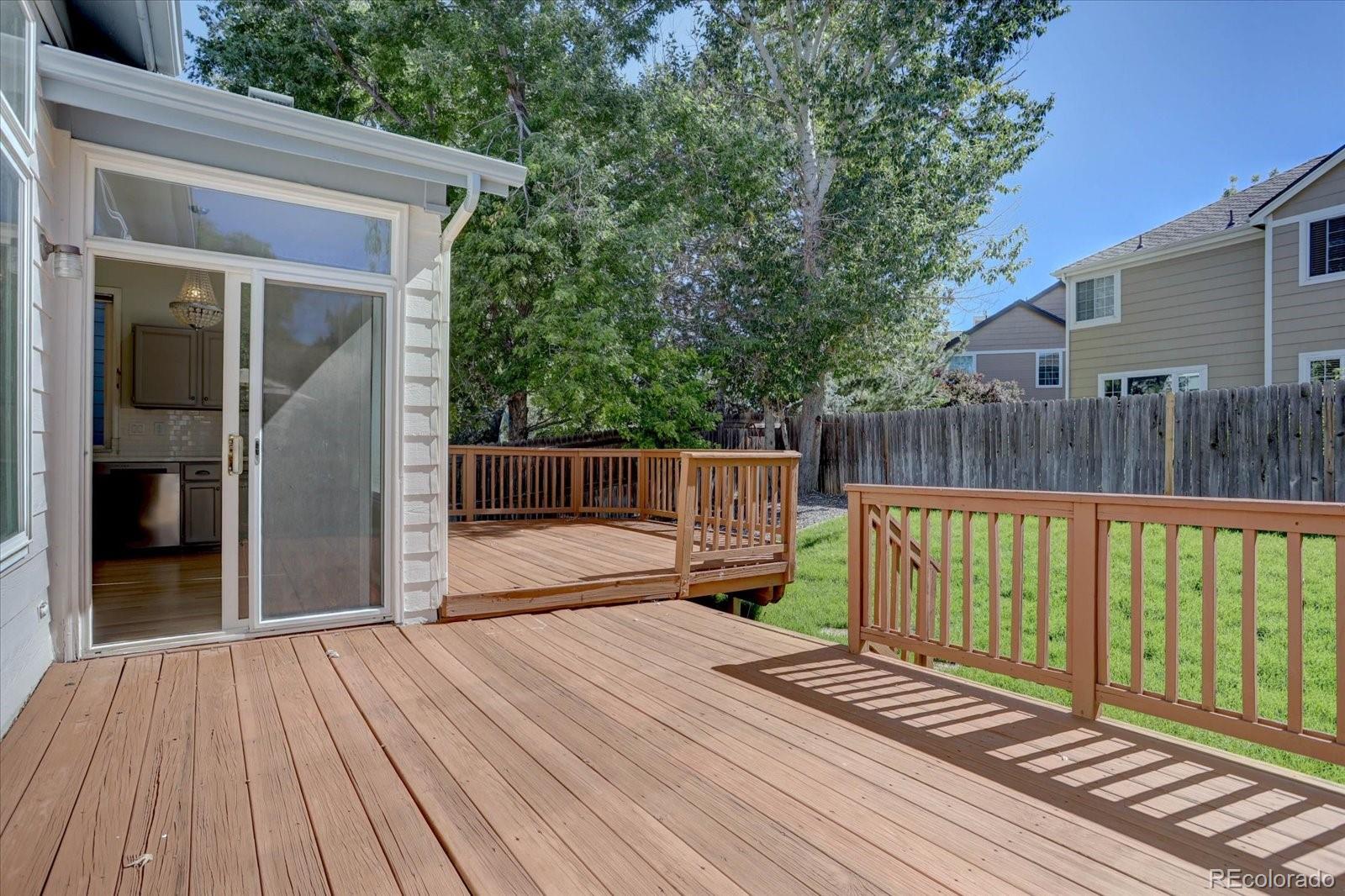 10312 Stoneflower Drive Parker, CO 80134 - Photo 36 of 43 a view of deck with wooden floor and fence next to a yard