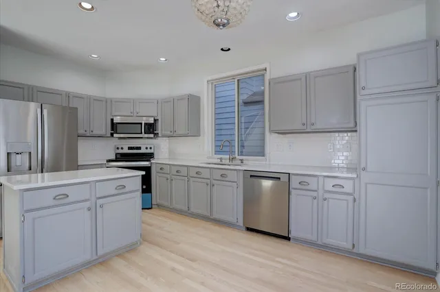 a kitchen with white cabinets and appliances