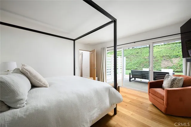 a bedroom with a large bed couch and a large window