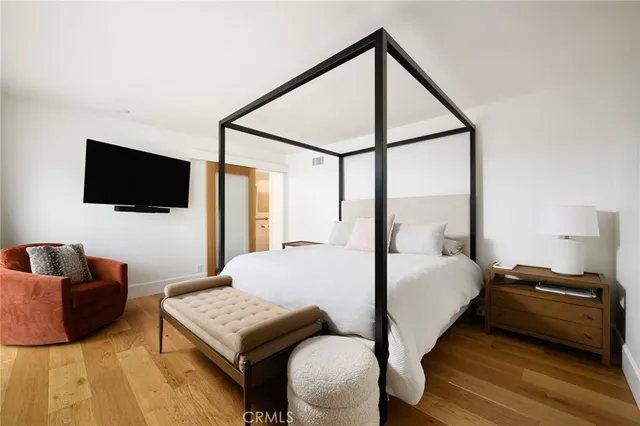 a bedroom with a bed window and a flat screen tv