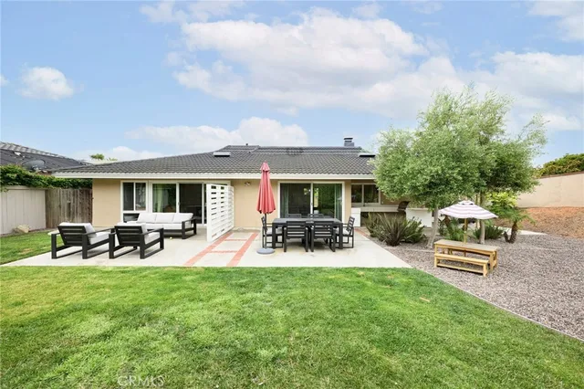 a view of a house with backyard and sitting area