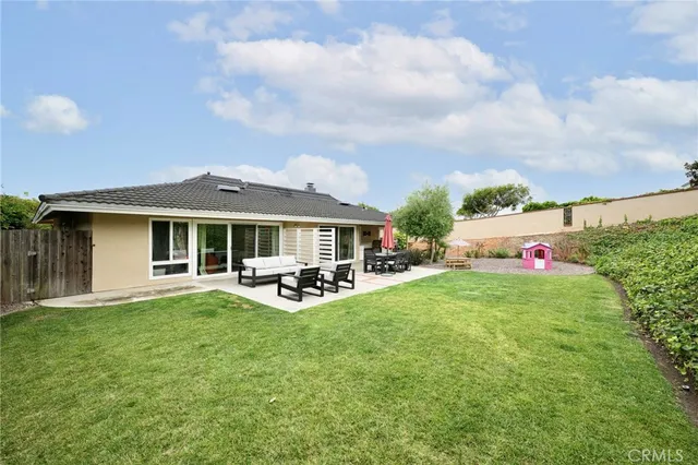 a view of a house with backyard sitting area and garden