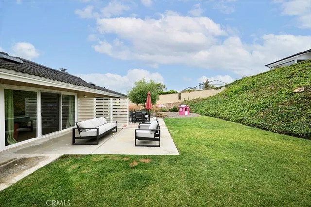 a view of a house with backyard sitting area and garden
