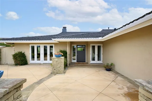 a view of house with backyard and glass windows
