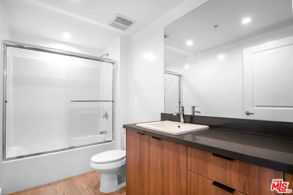 a bathroom with a granite countertop sink toilet and shower