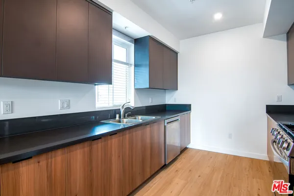 a kitchen with granite countertop a sink a stove and cabinets