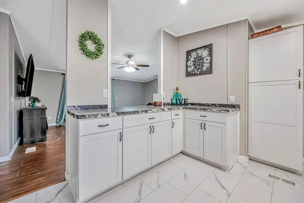a kitchen with stainless steel appliances granite countertop a refrigerator sink and white cabinets