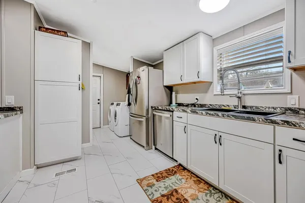 a kitchen with stainless steel appliances a refrigerator sink and cabinets