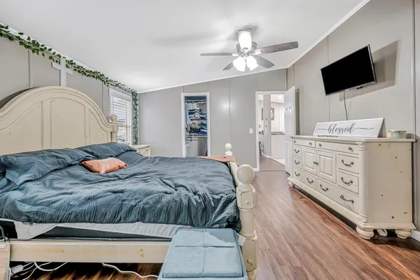 a bedroom with a large bed and flat tv screen on dresser
