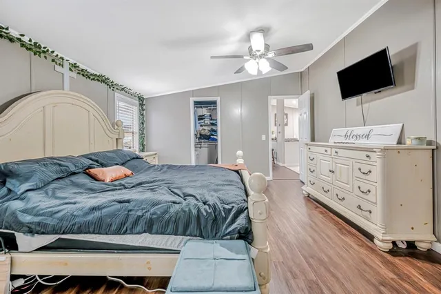a bedroom with a large bed and flat tv screen on dresser