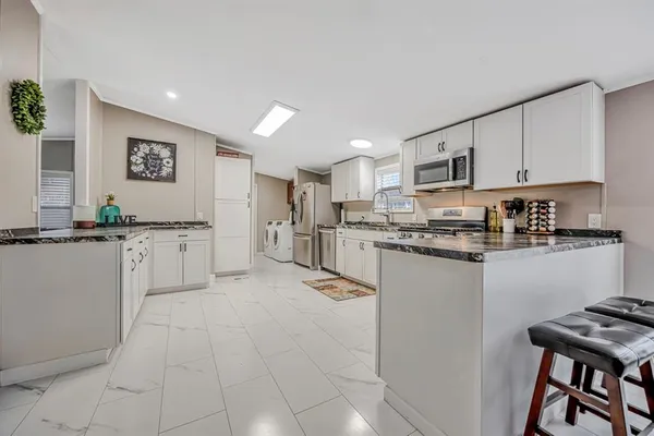 a kitchen with cabinets and chairs