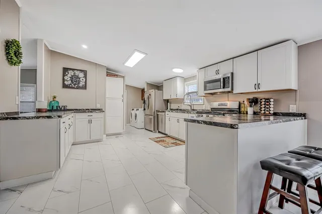 a kitchen with cabinets and chairs