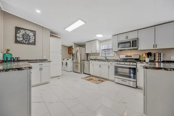 a kitchen with white cabinets and appliances