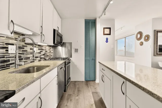 a kitchen with stainless steel appliances granite countertop a sink and a stove