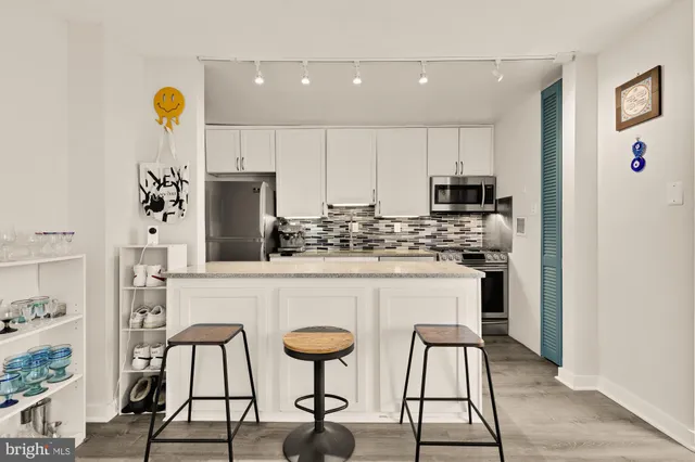 a kitchen with stainless steel appliances kitchen island granite countertop a refrigerator and microwave