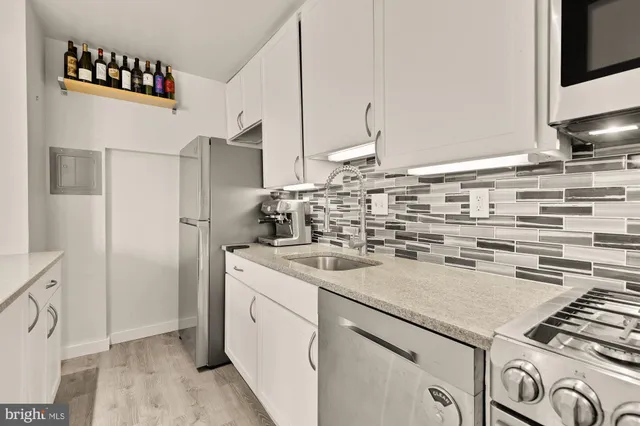 a kitchen with stainless steel appliances a sink and a refrigerator