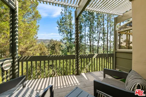 a balcony with wooden floor table and chairs