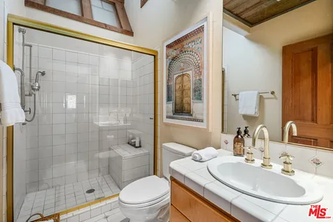 a bathroom with a sink a toilet and shower