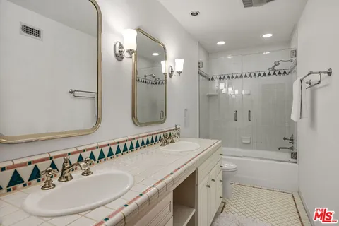 a bathroom with a granite countertop sink a mirror a shower and a bathtub