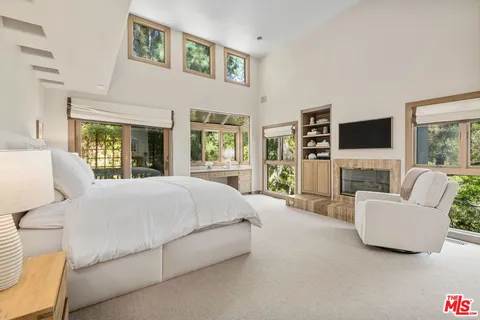 a spacious bedroom with a large bed and a flat screen tv