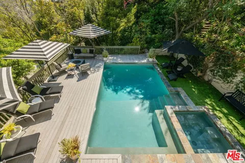 a view of a swimming pool with a patio and a garden