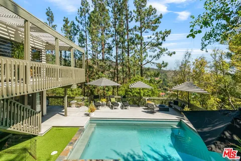 a view of a swimming pool with a patio and a yard