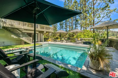 a view of a patio with couches and table and chairs under an umbrella