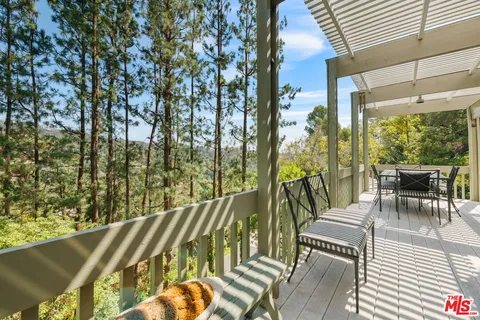 a view of a patio with table and chairs and floor to ceiling window with wooden floor