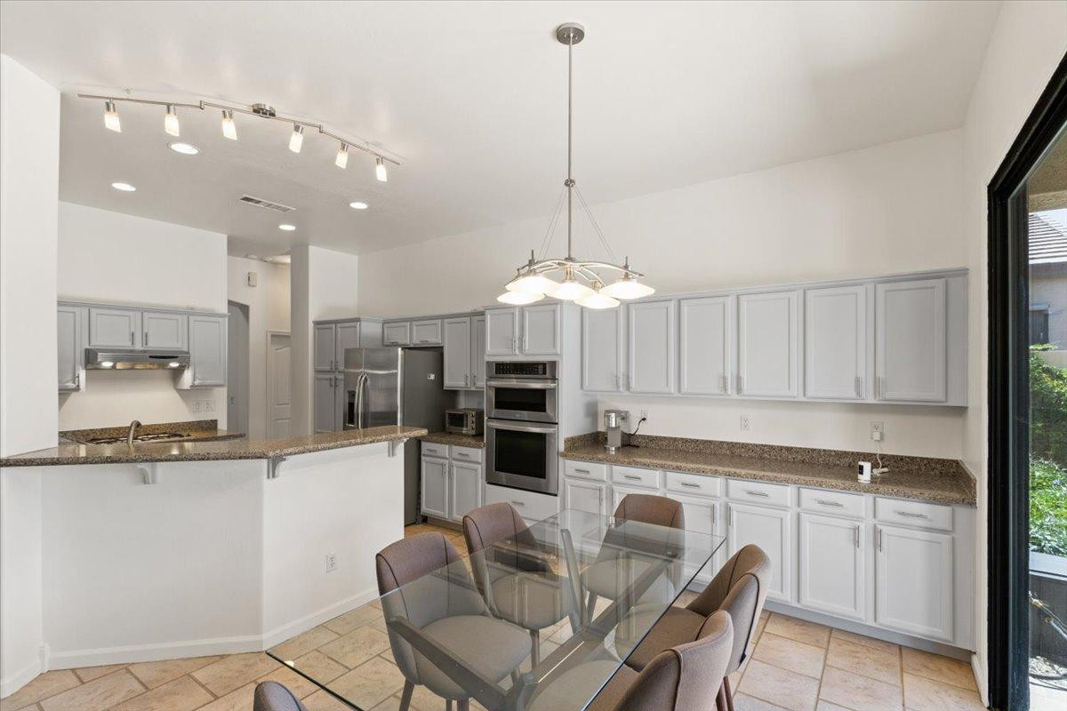 4211 East Kirkland Road Phoenix, AZ 85050 - Photo 5 of 23 a kitchen with stainless steel appliances granite countertop a refrigerator a sink dishwasher a stove and white cabinets with wooden floor