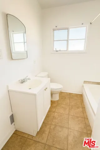 a bathroom with a sink a toilet and mirror