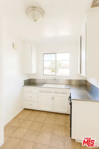 a kitchen with a sink cabinets and window