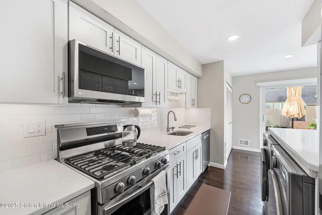 a kitchen with stainless steel appliances a stove a sink and a microwave