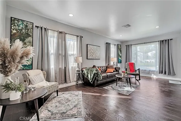 a living room with furniture and a wooden floor