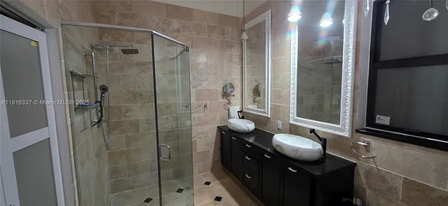 a bathroom with a double vanity sink toilet mirror and shower