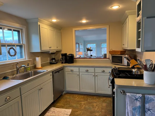 a kitchen with sink a stove and cabinets